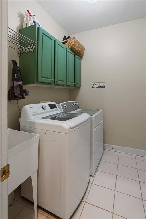 laundry area with washer and dryer, light tile patterned flooring, and cabinet space