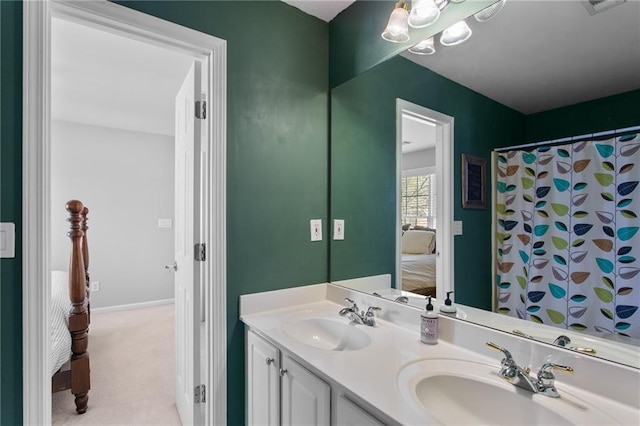 ensuite bathroom featuring a sink, baseboards, ensuite bathroom, and double vanity