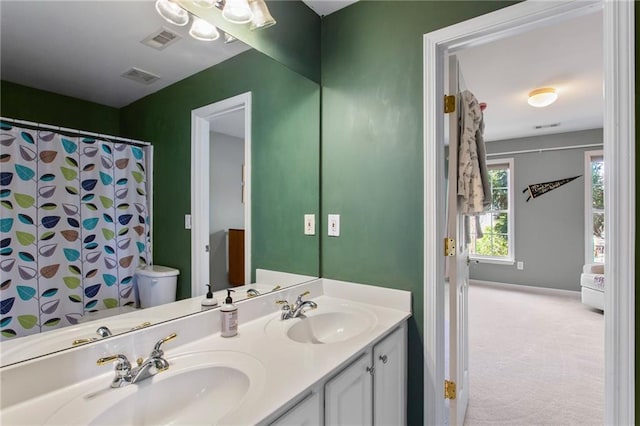 full bath featuring a sink, visible vents, and double vanity