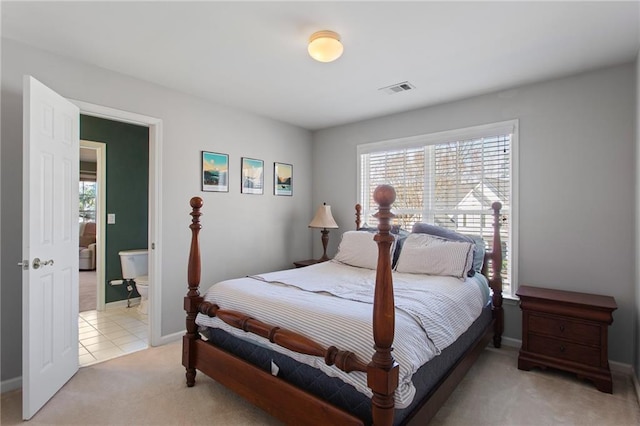 bedroom featuring light tile patterned floors, visible vents, baseboards, and light carpet