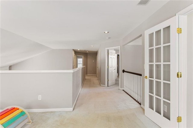 hallway featuring vaulted ceiling, recessed lighting, visible vents, and light carpet