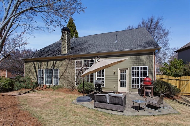 rear view of property with a patio, fence, a yard, outdoor lounge area, and a chimney