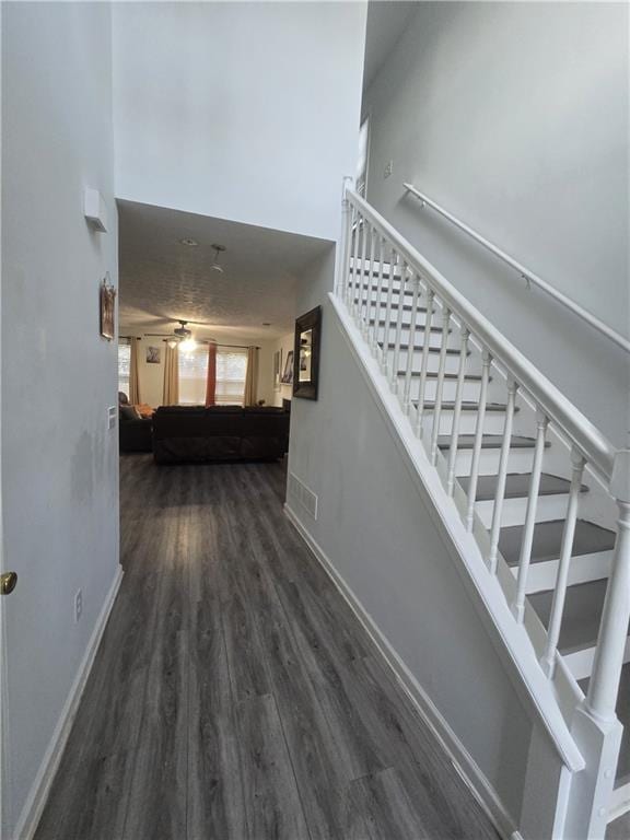 stairway with hardwood / wood-style flooring and ceiling fan