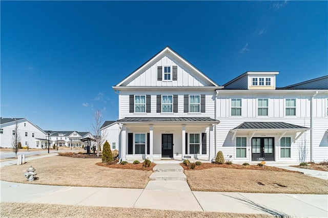 view of front of house featuring metal roof, a porch, french doors, board and batten siding, and a standing seam roof