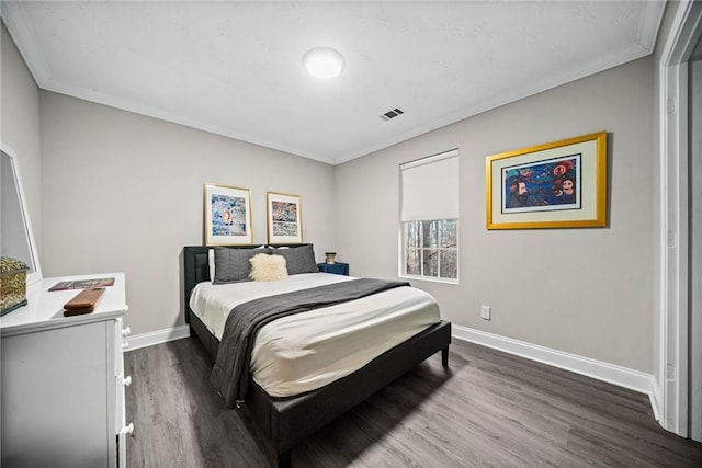 bedroom featuring ornamental molding and dark hardwood / wood-style flooring