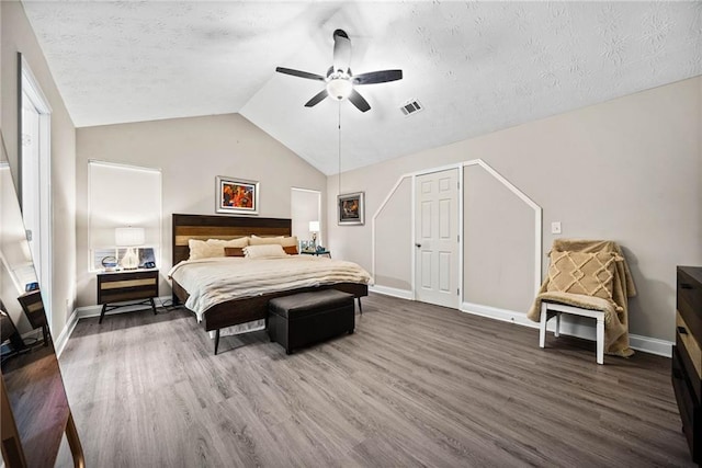 bedroom featuring vaulted ceiling, ceiling fan, a textured ceiling, and dark hardwood / wood-style flooring