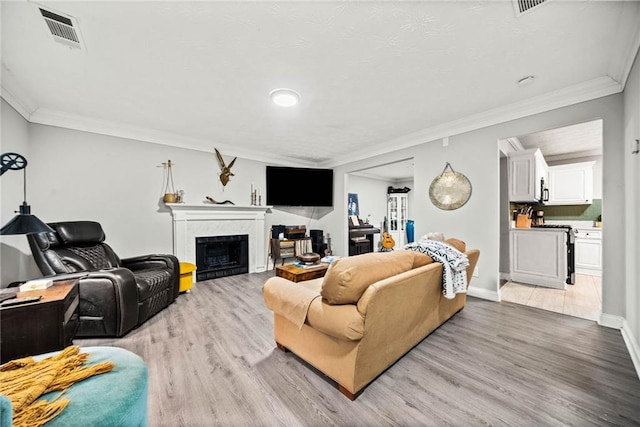 living room with ornamental molding and light hardwood / wood-style flooring