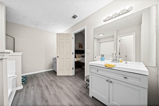 bathroom featuring vanity, hardwood / wood-style floors, and a textured ceiling