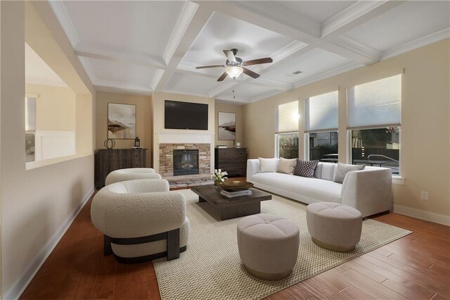 living room featuring hardwood / wood-style flooring, beam ceiling, a stone fireplace, and coffered ceiling