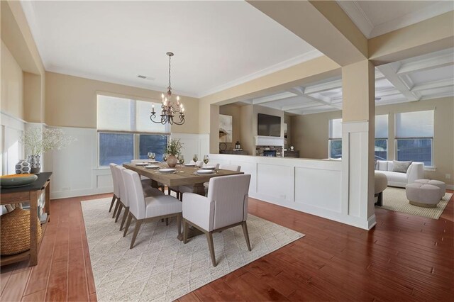 dining area with beam ceiling, coffered ceiling, a notable chandelier, hardwood / wood-style floors, and ornamental molding