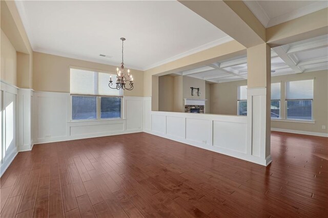 interior space with beam ceiling, dark wood-type flooring, coffered ceiling, crown molding, and a chandelier