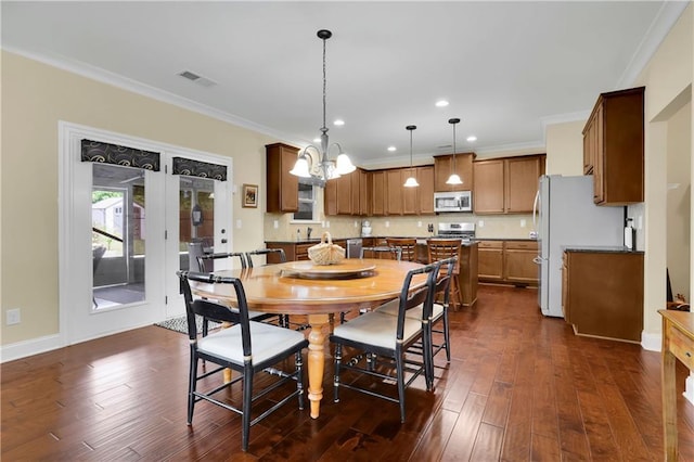 dining space featuring a chandelier, dark hardwood / wood-style floors, and ornamental molding