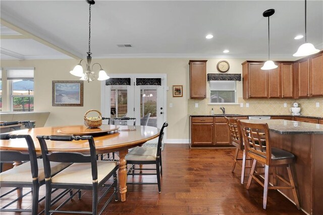 dining space featuring a chandelier, dark hardwood / wood-style flooring, crown molding, and sink