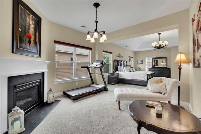 carpeted bedroom with a tray ceiling and a chandelier