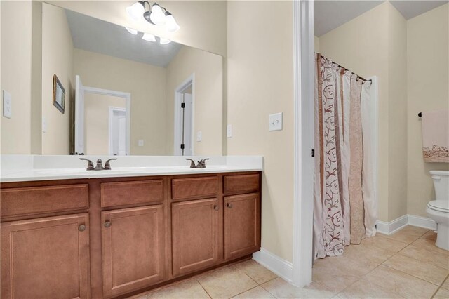 bathroom with tile patterned floors, vanity, a notable chandelier, and toilet