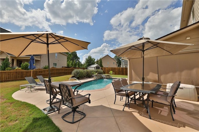 view of swimming pool with pool water feature, a yard, and a patio