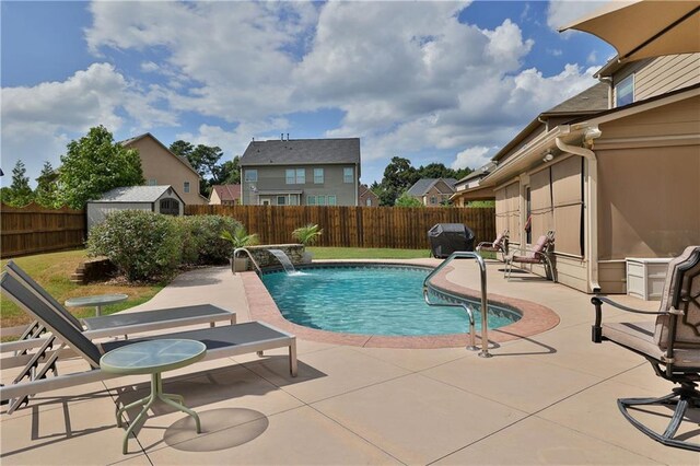 view of pool featuring a patio area, pool water feature, and a grill