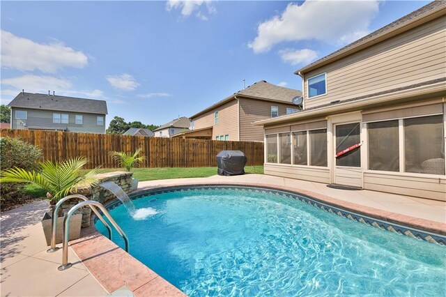 view of pool featuring a sunroom, pool water feature, and a patio area