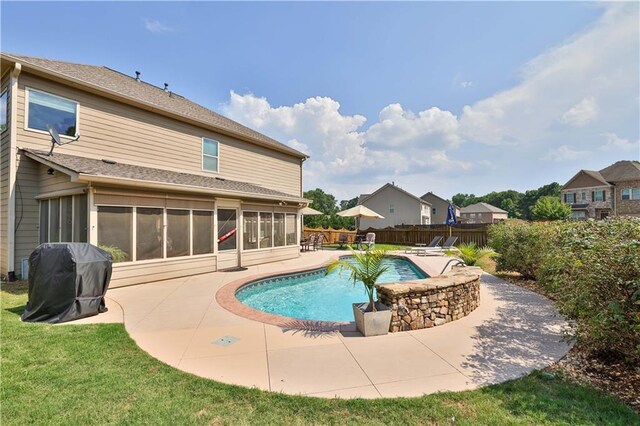 view of pool with a lawn, a grill, a sunroom, and a patio