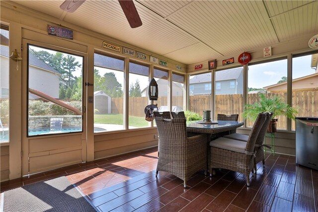 sunroom with ceiling fan and wood ceiling