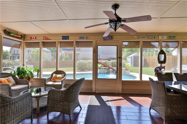 sunroom featuring ceiling fan and plenty of natural light