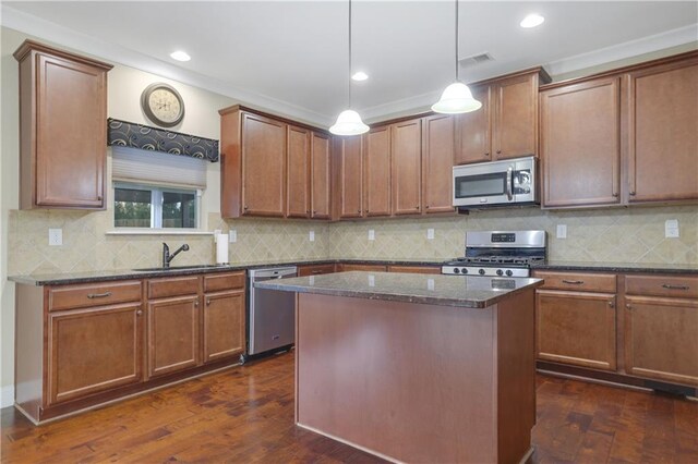 kitchen with dark stone counters, stainless steel appliances, dark wood-type flooring, sink, and a center island