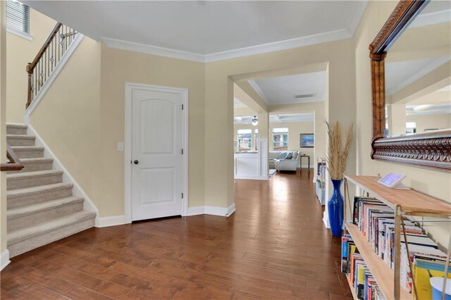 foyer featuring crown molding and dark wood-type flooring