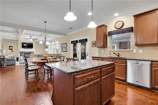 kitchen with dark stone countertops, decorative light fixtures, stainless steel dishwasher, and coffered ceiling