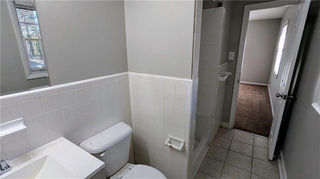 bathroom featuring tile patterned flooring, vanity, tile walls, and toilet