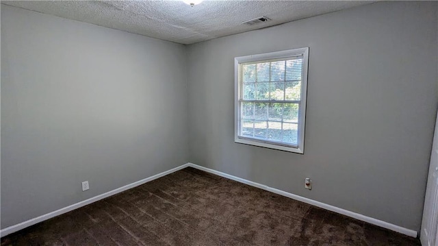 carpeted spare room featuring a textured ceiling