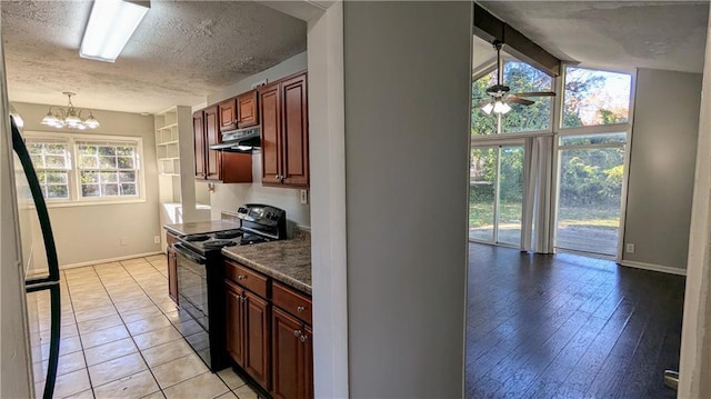 kitchen featuring light wood-type flooring, a textured ceiling, black range with electric cooktop, and a wealth of natural light