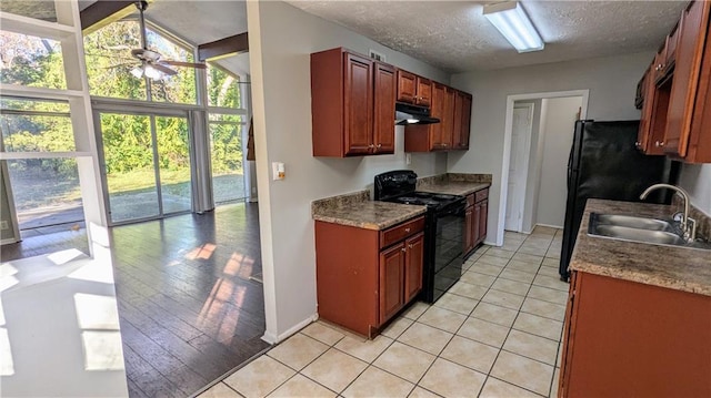 kitchen featuring light wood-type flooring, a textured ceiling, black range with electric cooktop, sink, and lofted ceiling