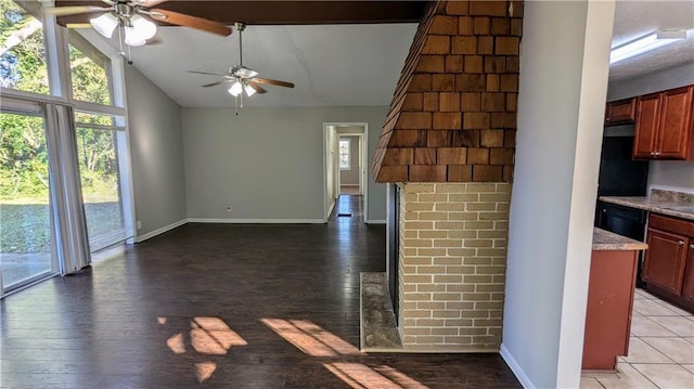 unfurnished living room with ceiling fan, dark wood-type flooring, and high vaulted ceiling