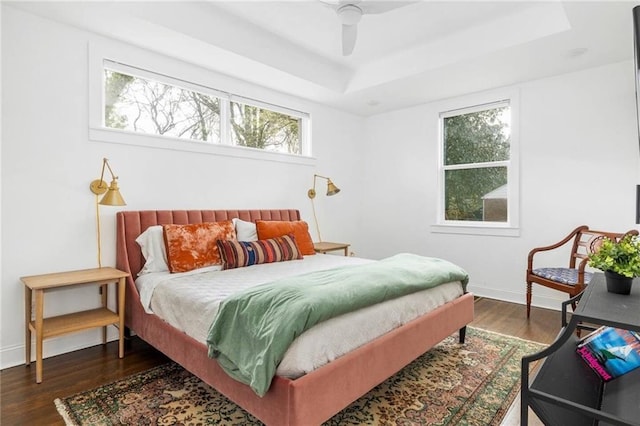 bedroom with ceiling fan, multiple windows, and dark hardwood / wood-style flooring