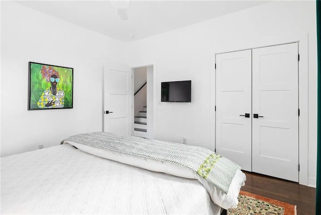 bedroom with a closet, dark hardwood / wood-style floors, and ceiling fan