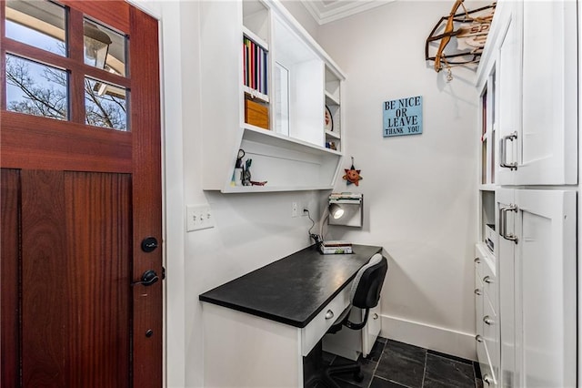 office space with baseboards, ornamental molding, and built in desk