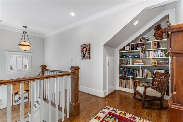 living area with ornamental molding, wood finished floors, baseboards, recessed lighting, and an upstairs landing