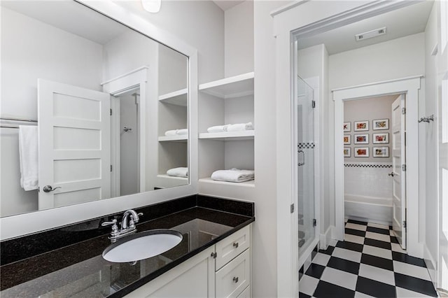 full bathroom featuring vanity, tile patterned floors, a stall shower, and visible vents