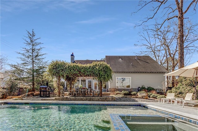 view of swimming pool featuring a pool with connected hot tub and a patio area