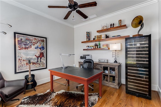 office area with crown molding, ceiling fan, beverage cooler, baseboards, and wood finished floors