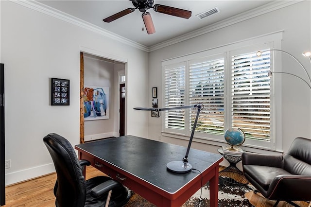 office area with visible vents, crown molding, baseboards, ceiling fan, and light wood-style flooring