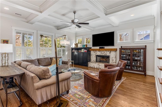 living area featuring ceiling fan, visible vents, a fireplace, beam ceiling, and coffered ceiling