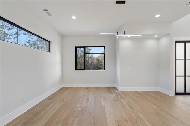 spare room featuring light hardwood / wood-style floors and a barn door