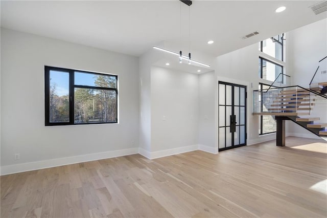 spare room featuring plenty of natural light and light hardwood / wood-style flooring