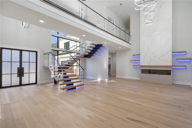 stairway featuring wood-type flooring and a towering ceiling