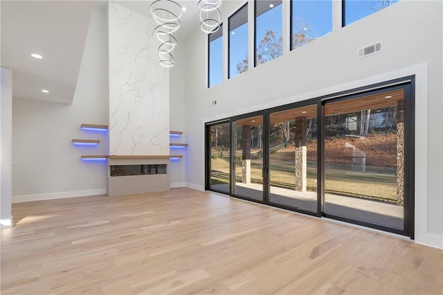 unfurnished living room with light wood-type flooring and a high end fireplace