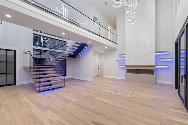 unfurnished living room featuring hardwood / wood-style floors, a fireplace, and a high ceiling