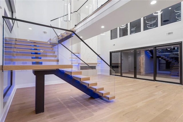 stairway featuring hardwood / wood-style floors and a high ceiling