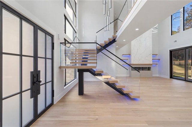 interior space with hardwood / wood-style floors, plenty of natural light, and a high ceiling