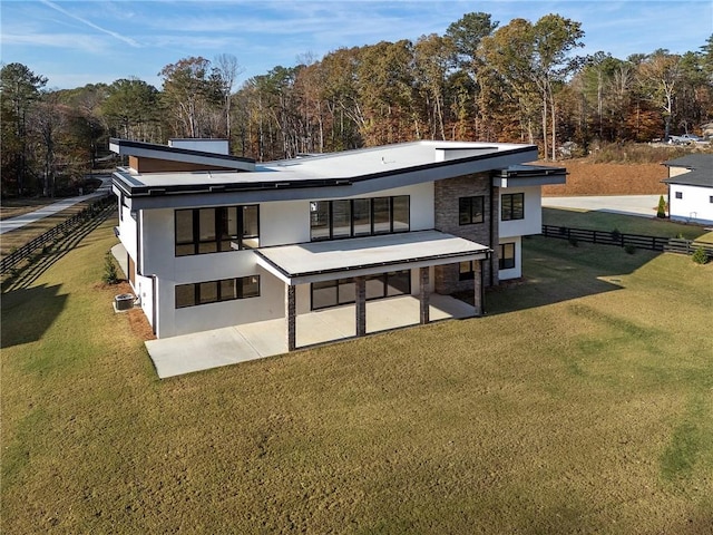 back of property with a yard and a patio area